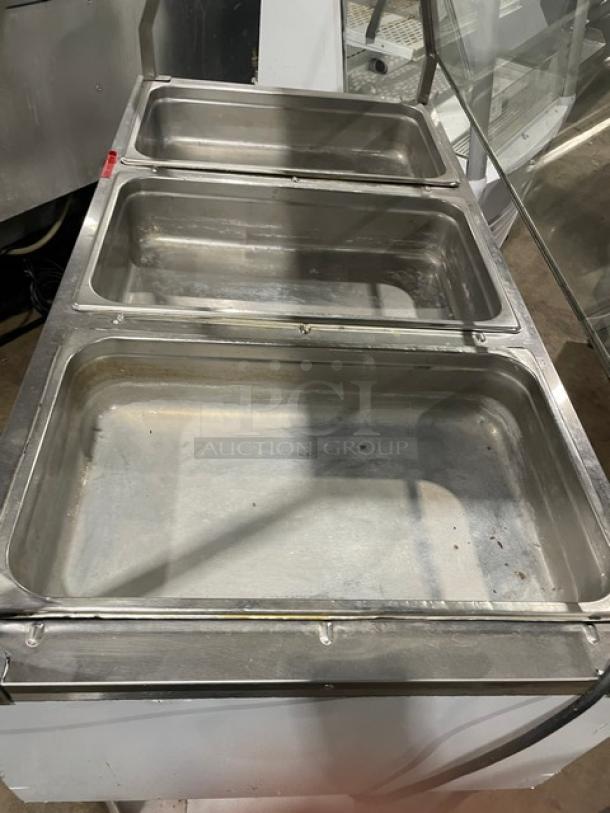 Serv-Ware EST31 stainless steel 3-well hot food table with sneeze guard, single undershelf, and legs, model SN: M1100228, 120V.