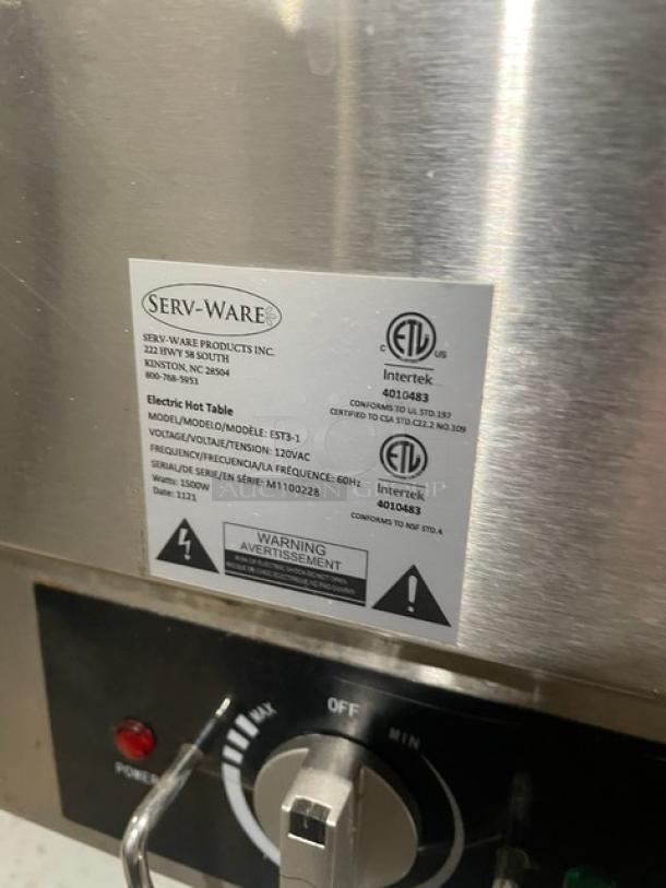 Serv-Ware EST3-1 stainless steel 3-well electric steam table with sneeze guard, undershelf, and label showing specs and serial number M1100228.