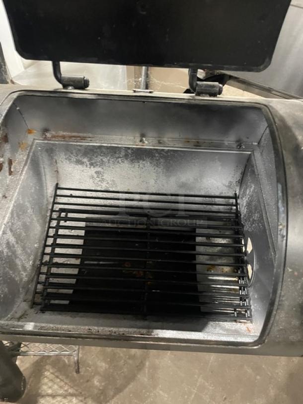 Brinkmann Professional Series charcoal offset smoker/grill, black, used condition, open chamber view with grill grates visible.