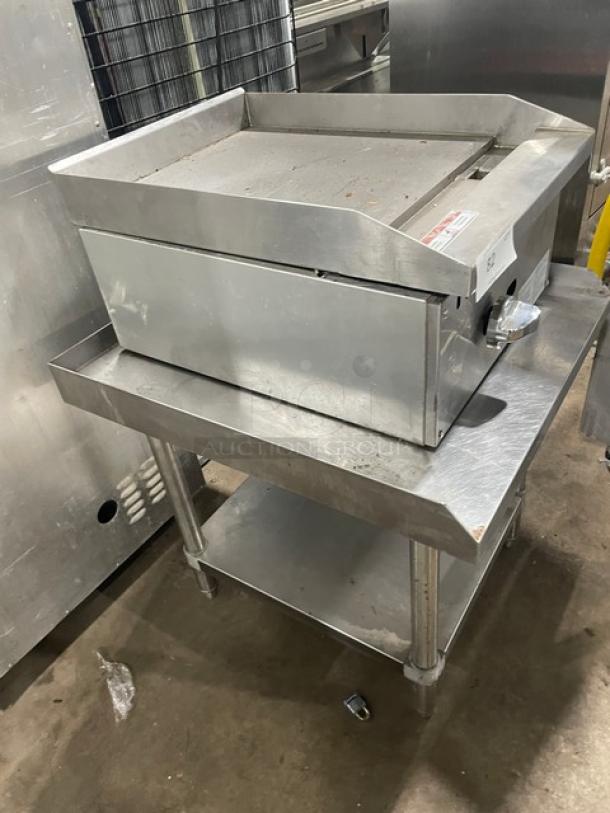 Adcraft ECTG16NG stainless steel countertop flat griddle on undershelf stand, with back and side splash, gas-powered, on legs.