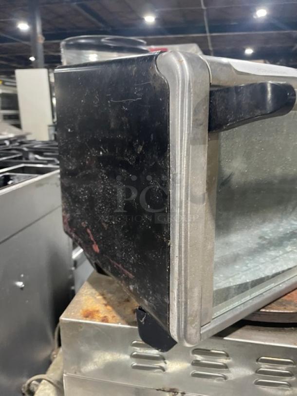 BLACK+DECKER TO3250XSB stainless steel convection toaster oven, extra wide, on legs, visible wear and scratches.