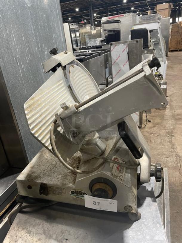 Univex Duro Series electric deli meat slicer, countertop model, commercial-grade, on legs, visible wear, model tag intact.