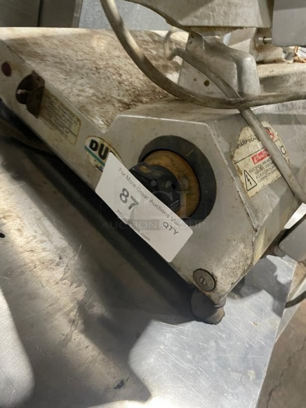 Univex Duro Series commercial electric deli meat slicer on legs, showing wear, with visible control dials and safety labels.