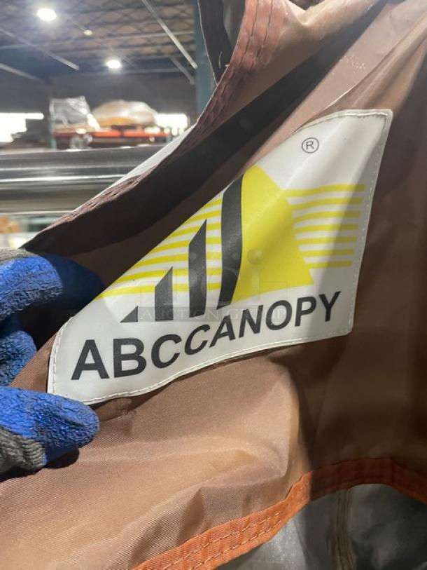ABCCanopy commercial brown foldable pop-up canopy tent, featuring branded tag with the ABCCanopy logo and durable fabric.