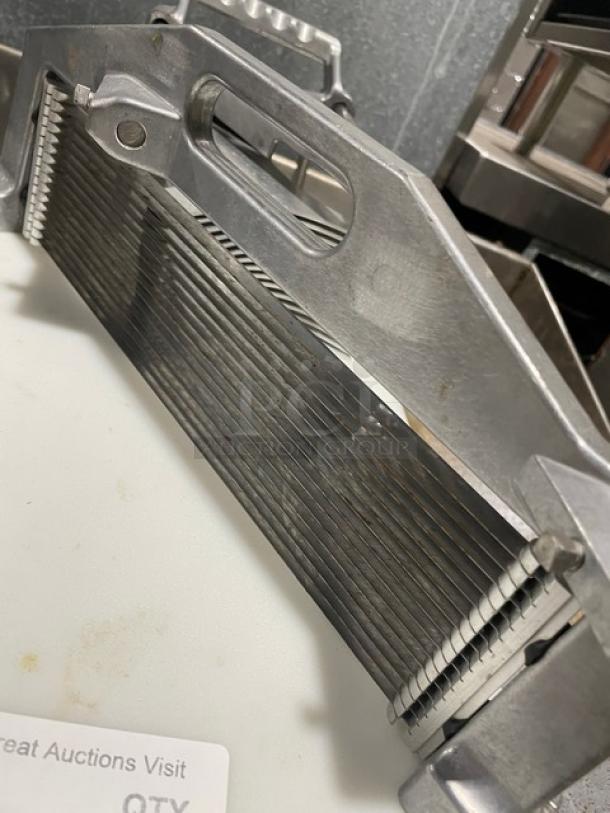 Commercial heavy-duty countertop tomato/vegetable slicer with cutting board, metal construction, used condition, on legs.