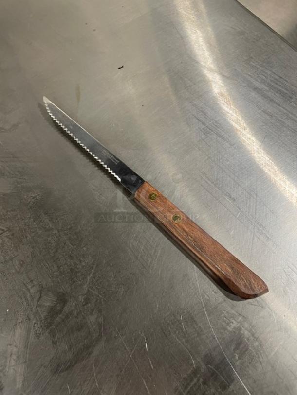Brand Ware Libbey/World Tableware 8" stainless steel steak knife with wooden grip handle, model 2001482. New condition.