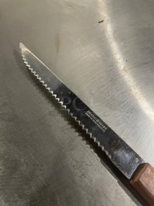 Brand Ware stainless steel 8" steak knife with wooden handle, serrated edge. Model 2001482 engraved on blade.