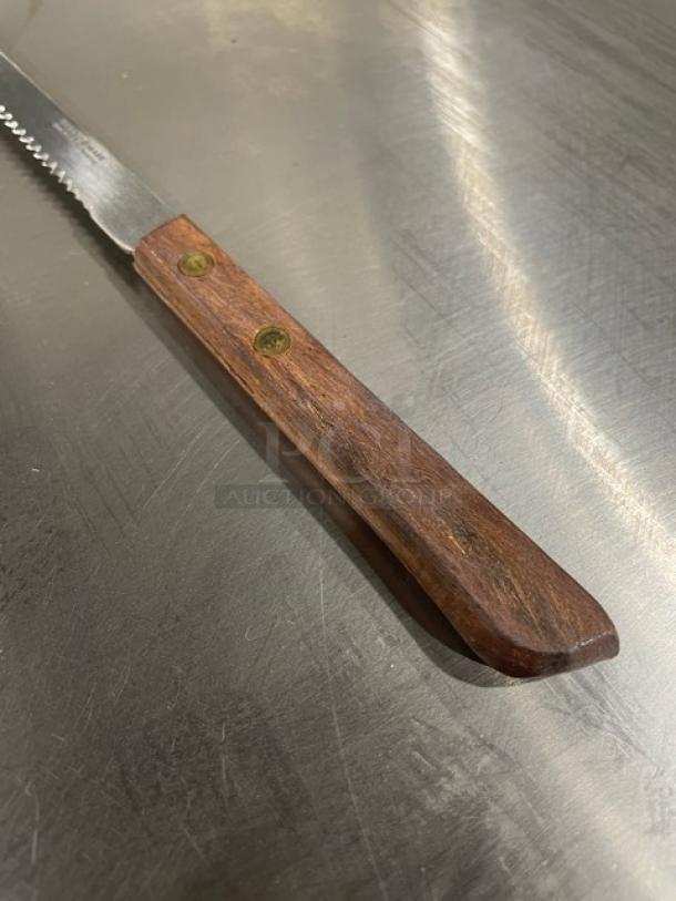 Brand Ware stainless steel 8" steak knife with wooden grip handle. Model 2001482. New condition.
