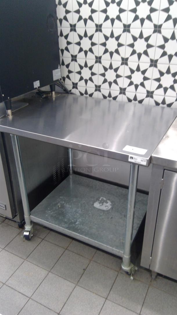 Boos 3' stainless steel table model FBLG3630 on casters, features a smooth top and lower shelf, in used condition.