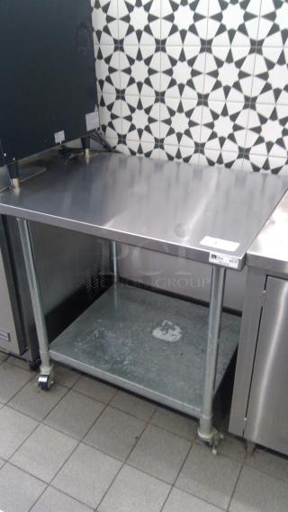 Boos 3' stainless steel table model FBLG3630 on casters, features a smooth top and lower shelf, in used condition.