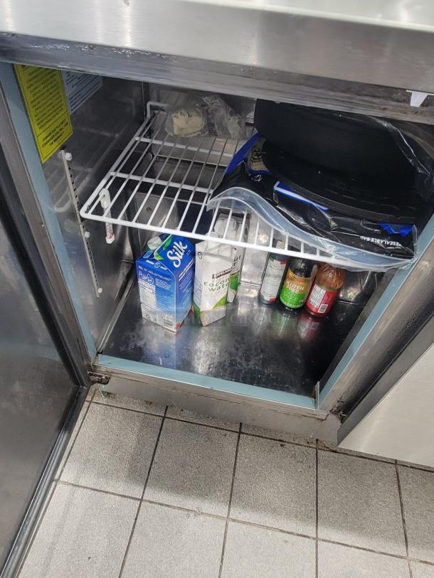 Supera 4' Refrigerated Work Top Counter PWTR48-SI, on casters, with interior shelves holding beverages and food items.