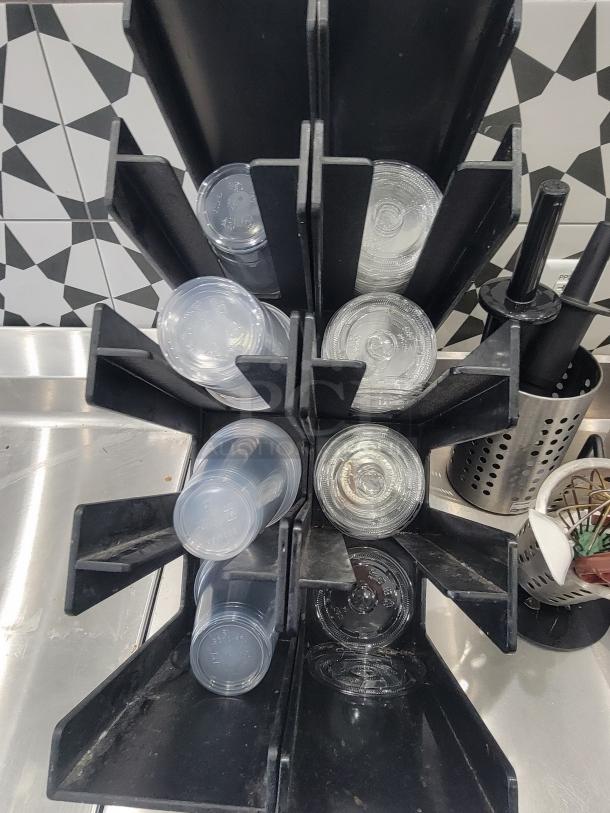 Commercial kitchen equipment holder with stacked clear plastic cups, in good used condition. Ideal for start-up cafes.