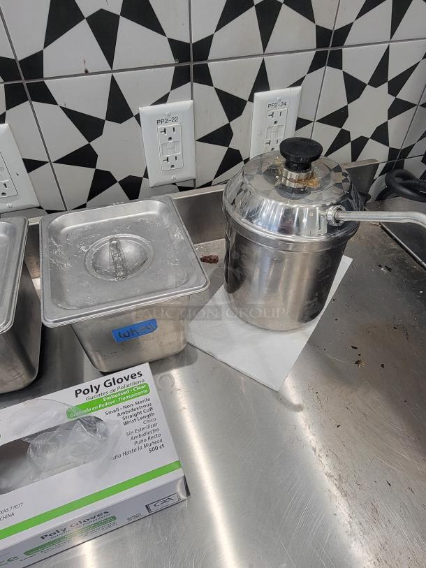 Commercial kitchen supplies lot, includes stainless steel containers, saucepan with handle, and box of poly gloves, in good used condition.