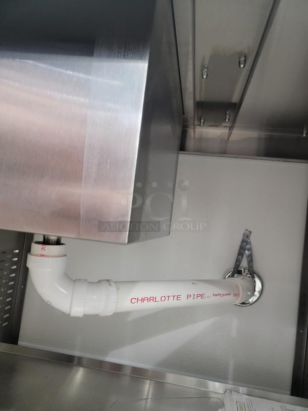 Alt text: Titan 3' cold well work station with shiny metal finish and visible drain sink piping, labeled Charlotte Pipe.