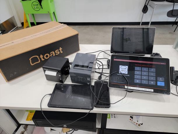 Complete Toast POS system including tablets, printers, and accessories on a countertop. Ideal for restaurants and cafes.
