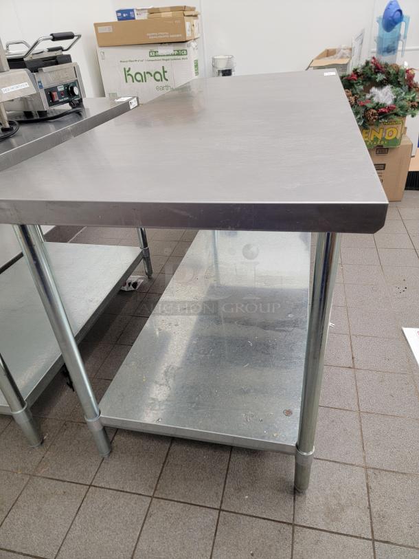 6-foot commercial stainless steel work table with undershelf, durable design, ideal for kitchens or workshops, in good condition.
