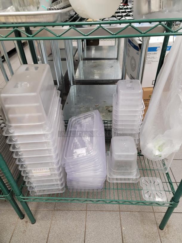 Bulk lot of stainless steel food pans in various sizes on a green Metro rack. Ideal for commercial kitchens.