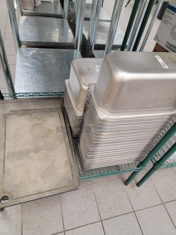 Commercial kitchen equipment lot with stainless pans, containers, and Metro shelving. Used condition, ideal for professional kitchens.