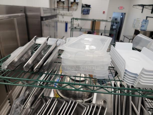 Commercial kitchen storage lot with stainless pans, plastic containers, and a Metro shelf in excellent condition. Ideal for professional kitchens.