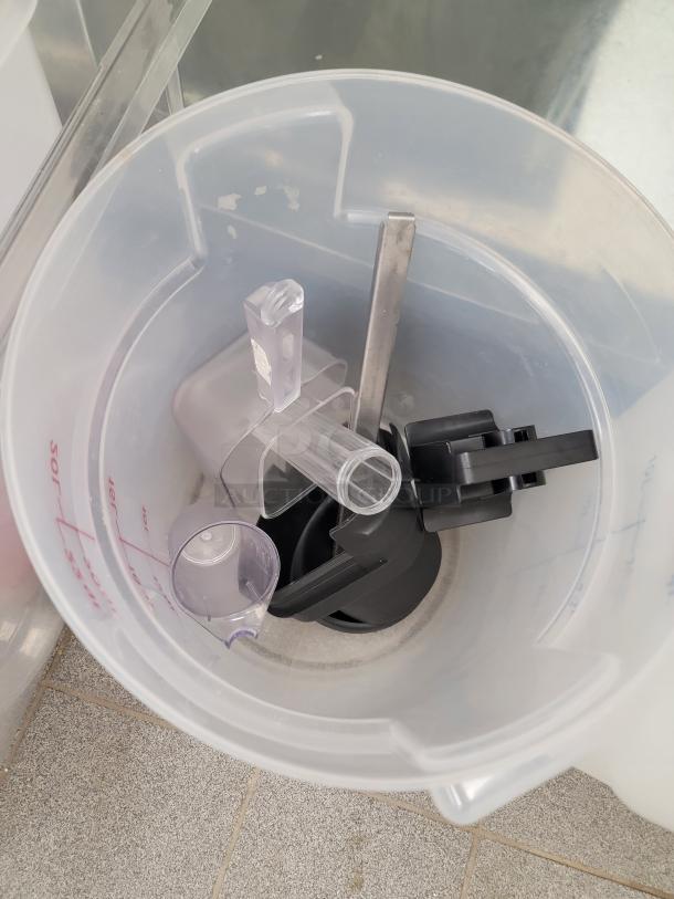 Translucent food storage container with black and clear dispensers inside, suitable for commercial use, in good condition.