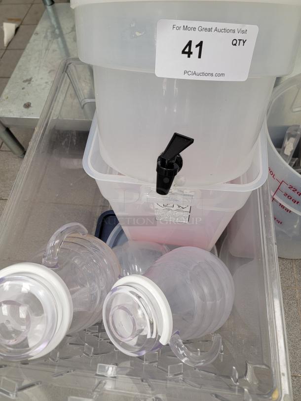Assorted kitchen essentials lot with translucent food storage containers and beverage dispensers. Commercial-grade quality.