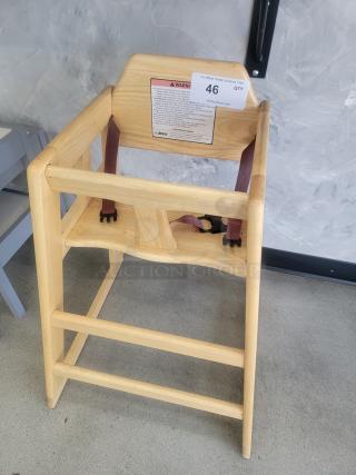 Winco Natural Wood Commercial High Chair with safety straps and ASTM compliance label, ideal for restaurants and daycares.
