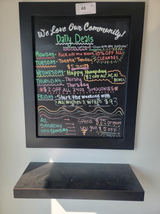 Wall-mounted chalkboard sign with shelf, used for daily deals. Black frame, colorful text. Auction label indicates item 48.