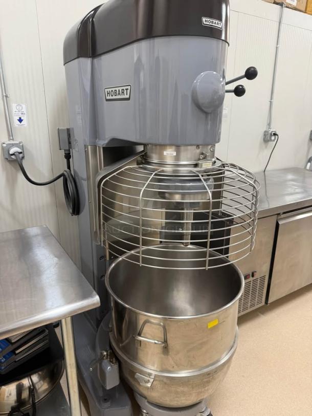 Hobart 1410 140Qt commercial mixer in like-new condition with guard, two mixing bowls, dolly, and paddle attachment.