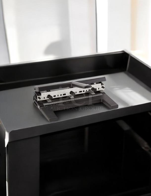 Swingline SWI450 hole punch machine on black surface, featuring adjustable metal components, in good condition.