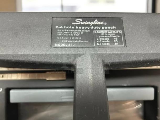 Swingline Model 450 heavy-duty hole puncher, 2-4 hole capacity. Black finish, excellent condition. Label indicates usage specs.