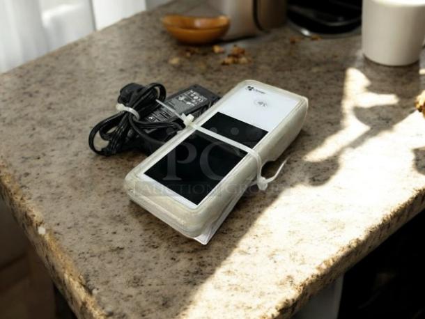 Clover Flex K400 device in great condition, with charger, on stone countertop. Fully tested and working.