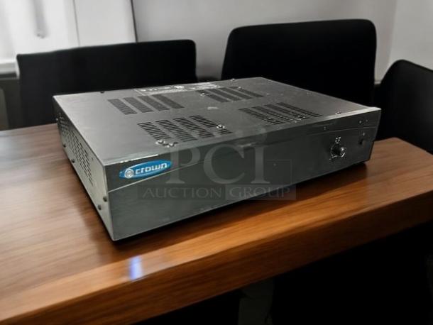 Crown 180A 80W power amplifier in excellent condition on a wooden table, with visible brand logo and ventilation grilles.