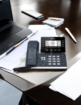 Yealink SIP-T53W desk phone with HD display, keypad, and coiled handset. Features several programmable buttons.