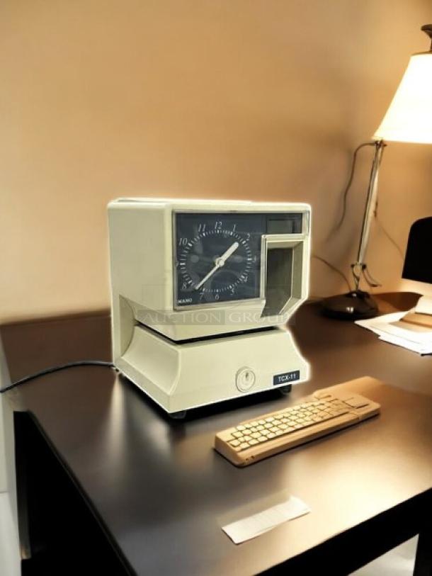 AMANO TCX-11 time clock in great condition, 6 7/8 in W, 8 1/4 in H. Fully tested and working, clear display and markings.