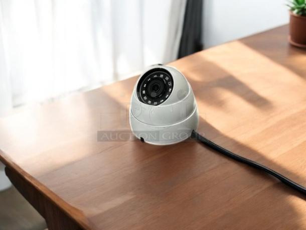 Dahua HDCVI security camera, white, in excellent condition, fully tested and working, shown with cable on wooden surface.