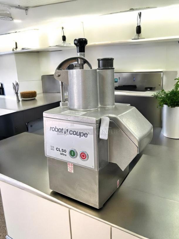 Robot Coupe CL50 food processor, perfect condition, 1 1/2 hp, includes 3 discs, tested and working, visible control buttons.