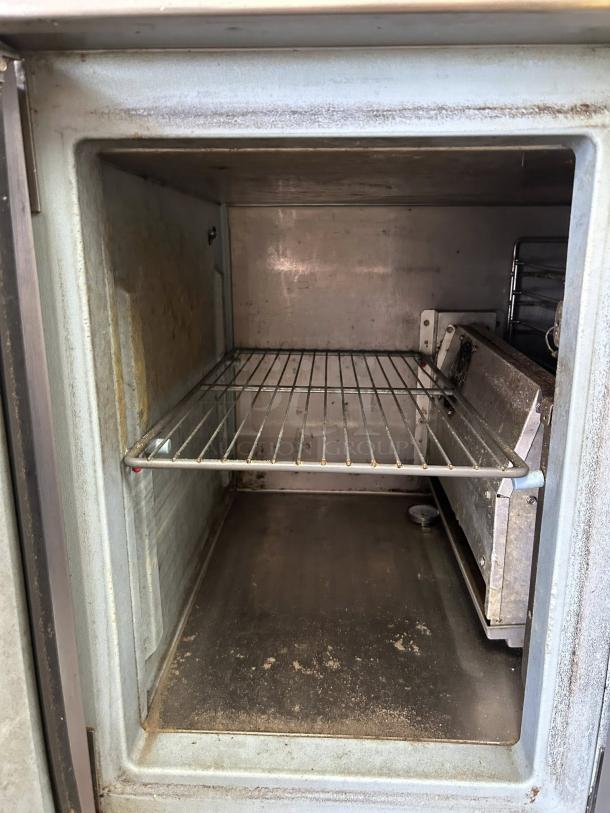 Delfield 91in 3-door refrigerated pizza prep unit; interior shelf visible, used condition, model 000-20191PTC.