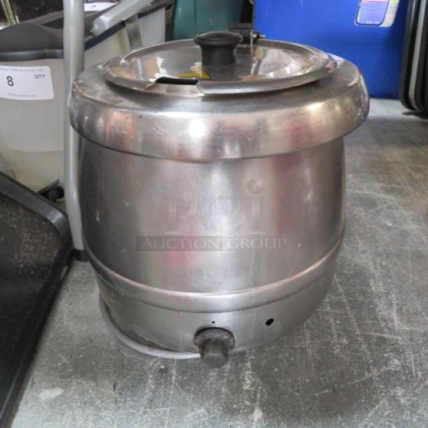 Stainless steel soup kettle, used condition, featuring a lid and spout. Light wear visible, no brand markings.