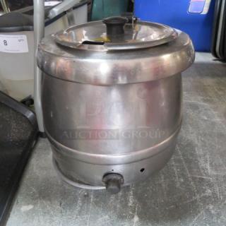 Stainless steel soup kettle, used condition, featuring a lid and spout. Light wear visible, no brand markings.