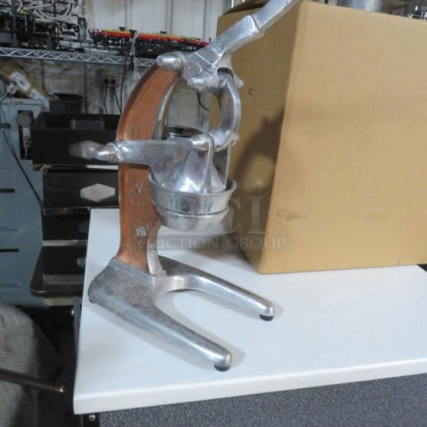 Vintage countertop citrus press, sturdy metal construction, hand lever, good condition. Ideal for efficient juice extraction.