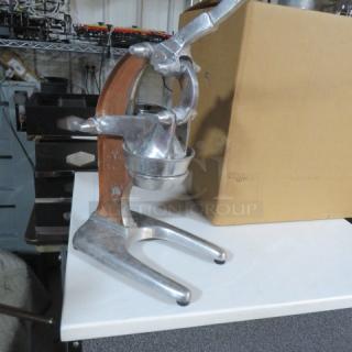 Vintage countertop citrus press, sturdy metal construction, hand lever, good condition. Ideal for efficient juice extraction.