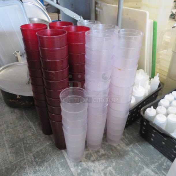 Lot of 24oz polycarbonate glasses in red and clear. Multiple stacks, used condition. Ideal for bulk purchase.