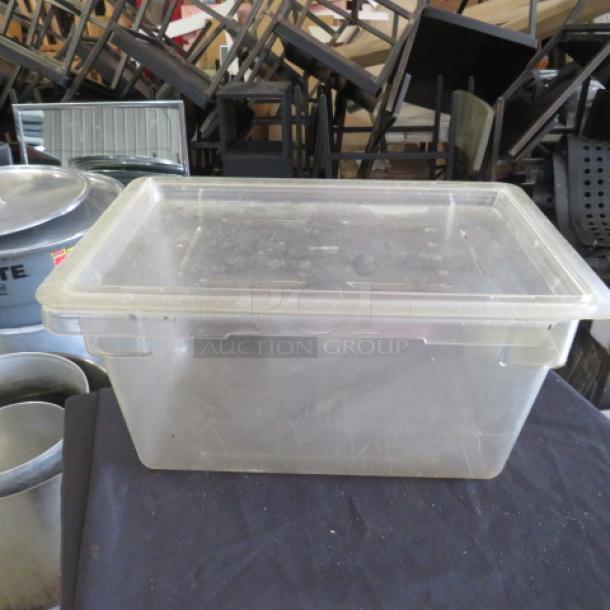 Clear 5-gallon food storage container with lid, used condition. Durable plastic material, suitable for bulk storage.