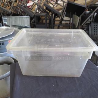 Clear 5-gallon food storage container with lid, used condition. Durable plastic material, suitable for bulk storage.