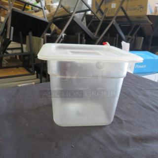 1/6 size 6-inch deep food storage container with lid, clear plastic, used, model 9XBID, on display table.