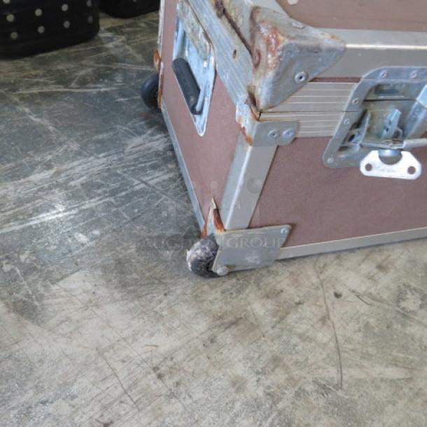 Viking equipment case, brown with metal edges, visible rust and wear, rolling wheels, sturdy metal latches, used condition.