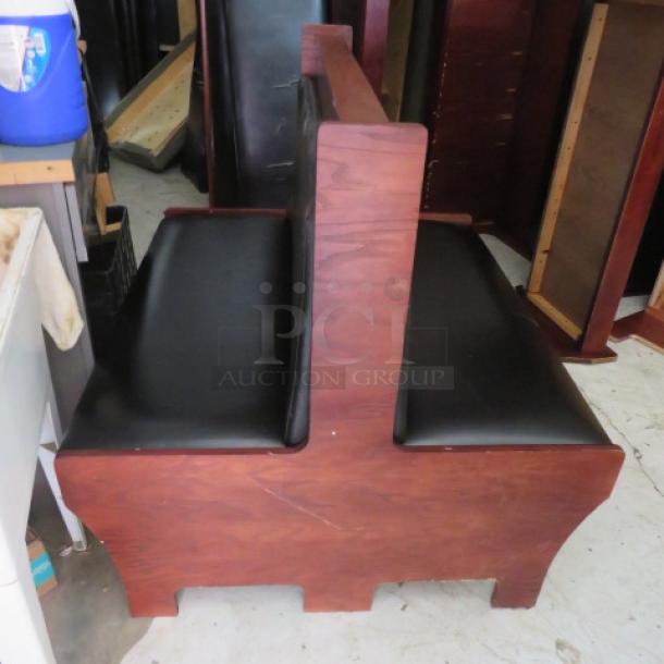 Double-sided wooden booth with black cushioned seat and back, excellent condition, ideal for restaurant use.