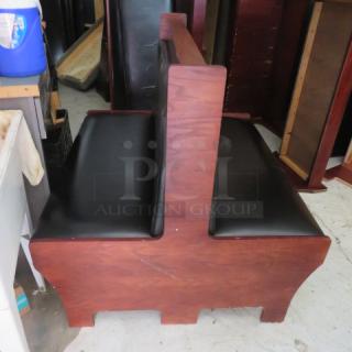 Double-sided wooden booth with black cushioned seat and back. Good condition, sturdy wood frame. Ideal for dining spaces.