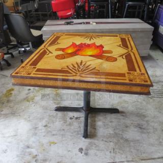 Custom wooden laminated table top with campfire design, 42x36x30 inches, on a pedestal base. Good condition.