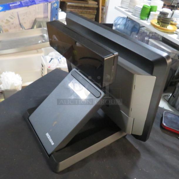 Hisense POS Terminal HK578, black, standing on a counter. Brand logo on the base; slight wear visible.